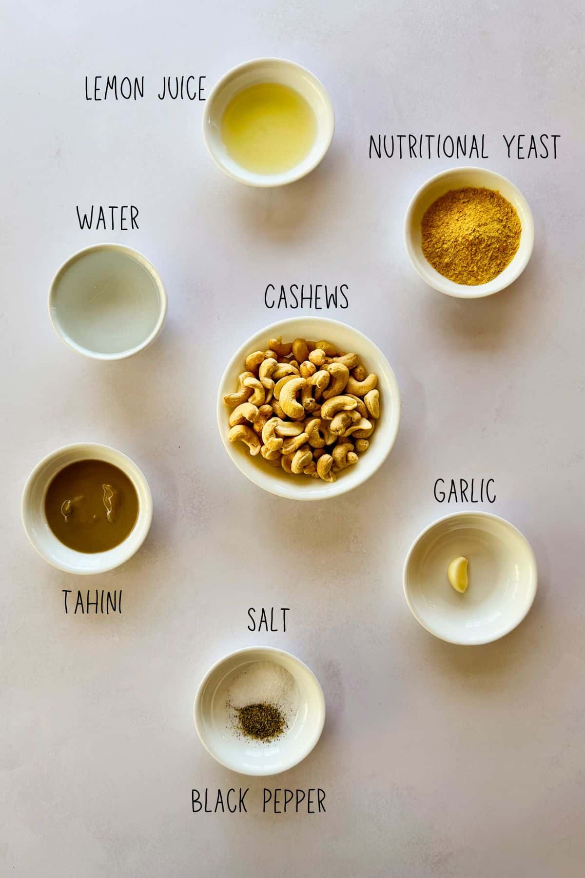 ingredients for easy vegan cashew cheese sauce Ingredients for vegan cashew cheese sauce in bowls.