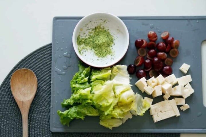 slice tofu dates and lettuce on grey chopping board