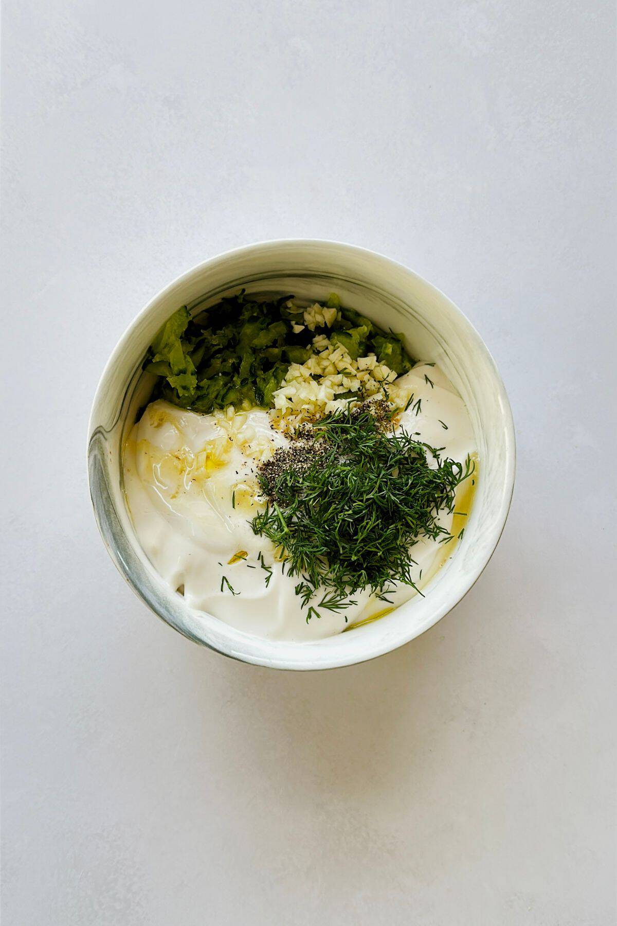 grated cucumber ingredients for the tzatziki in a bowl.
