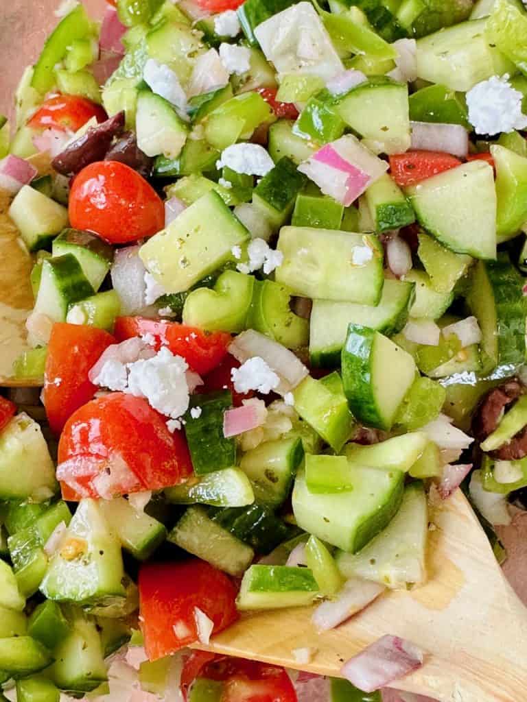 Close up look at Vegan Greek salad with vegan feta in a clear bowl