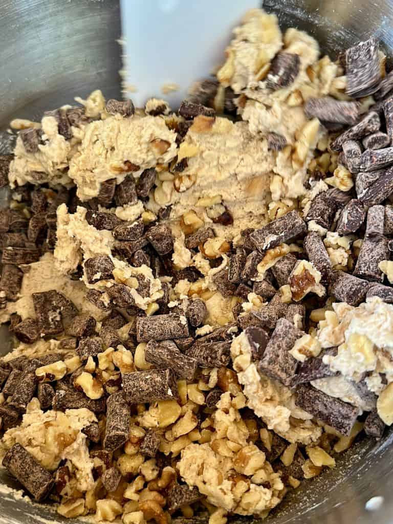 mixing cookie dough with vegan chocolate chips and walnuts