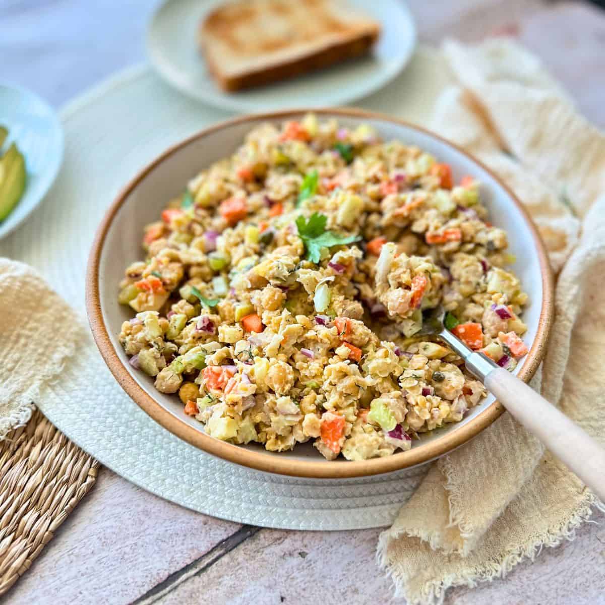vegan chickpea tuna salad in a bowl with a spoon.