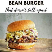 A chipotle black bean burger piled high with coleslaw on a toasted bun, with text reading 'How to Make Chipotle Black Bean Burger that doesn't fall apart.