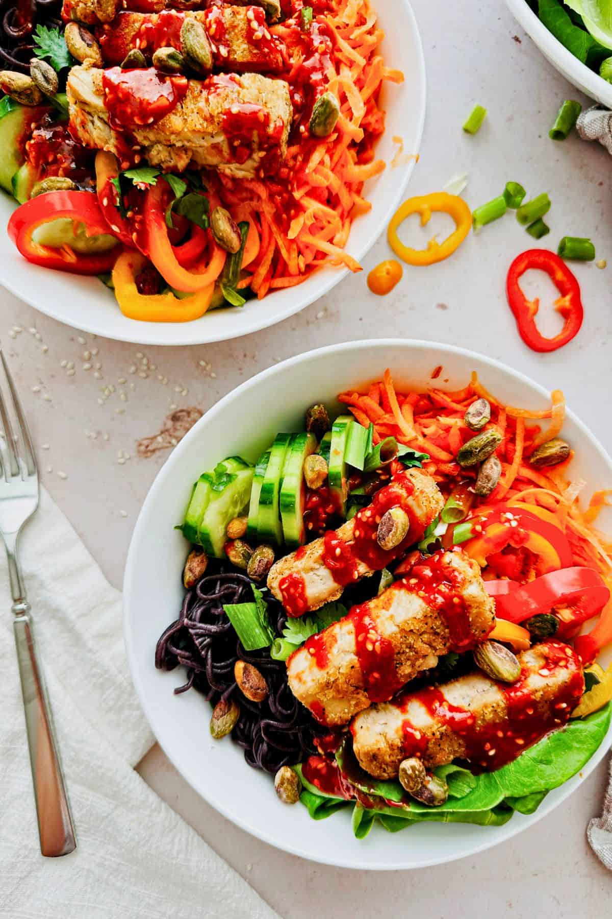 two bowls of Crispy Meati Chicken Noodle Bowls With Gochujang Sauce