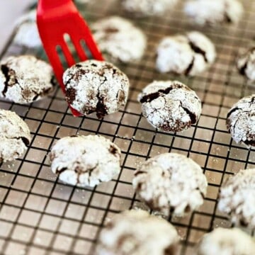 a spatula picking up Vegan Double Chocolate Crinkle Cookie from cooling tray