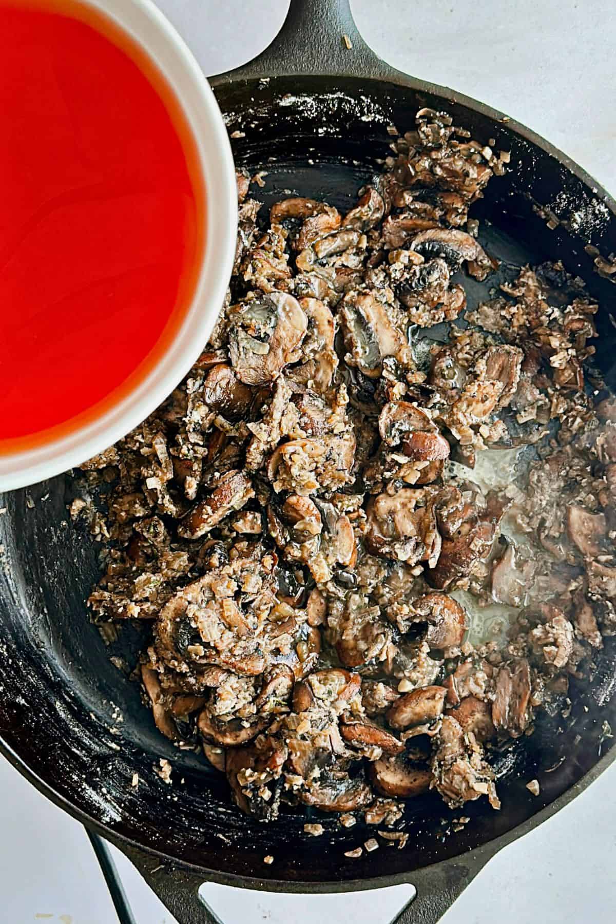 adding broth and butter to vegan mushroom gravy; top view