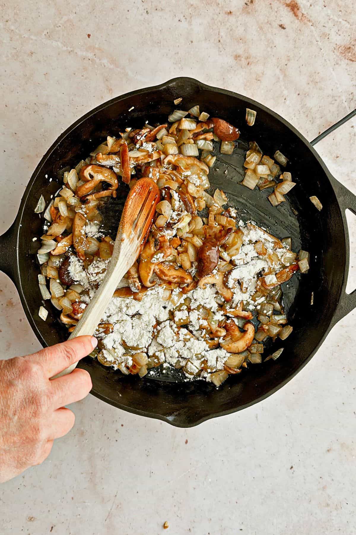 adding flour to pan to make roux