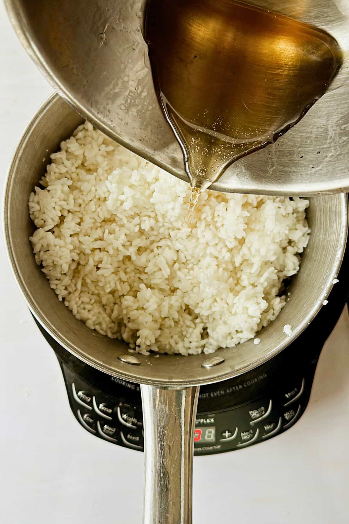 adding sugar mixture to cooked sushi rice