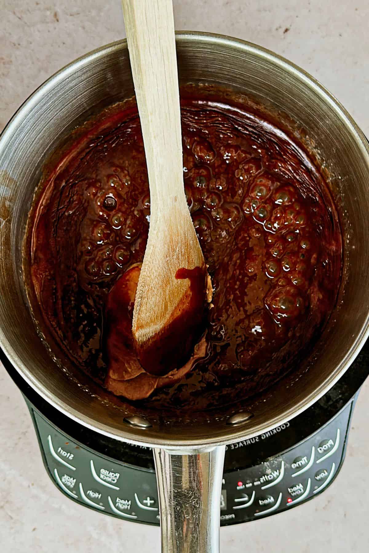 adding peanut butter to pot for vegan fondue