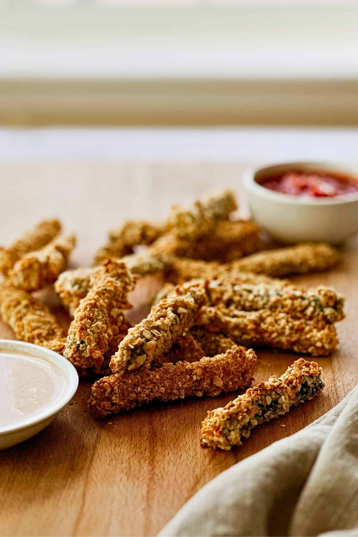 vegan panko baked zucchini fries on a cutting board with sauces