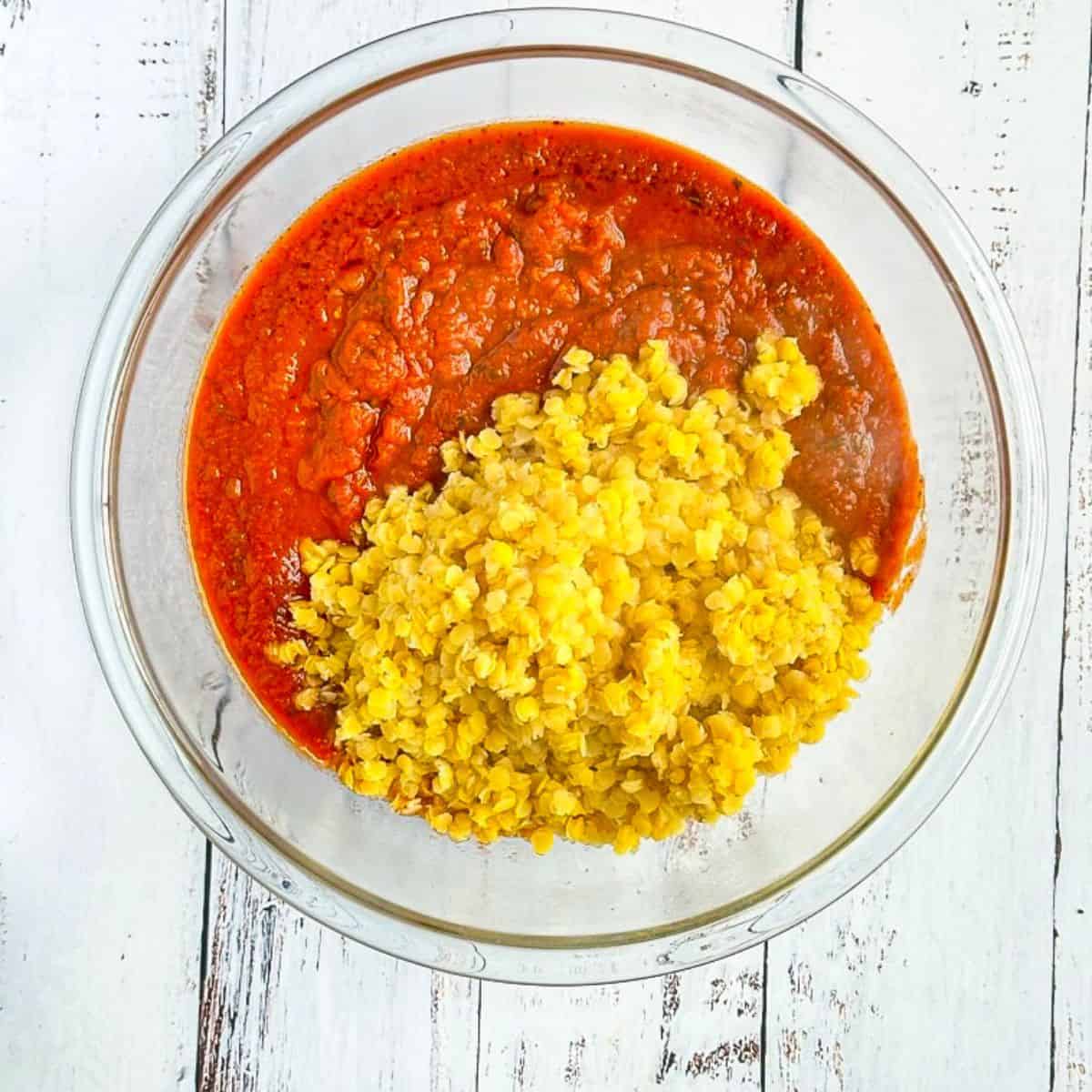 bowl with cooked red lentils with marinara sauce