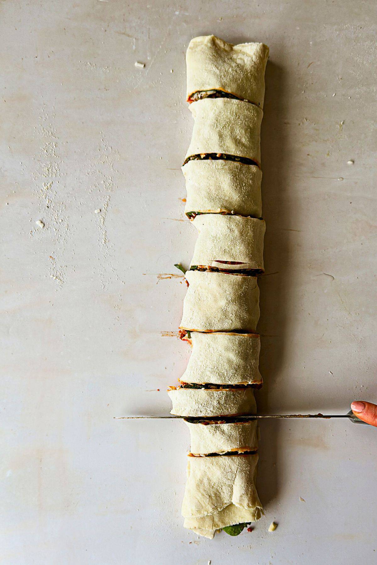 cutting the dough for vegan pizza rolls; top view