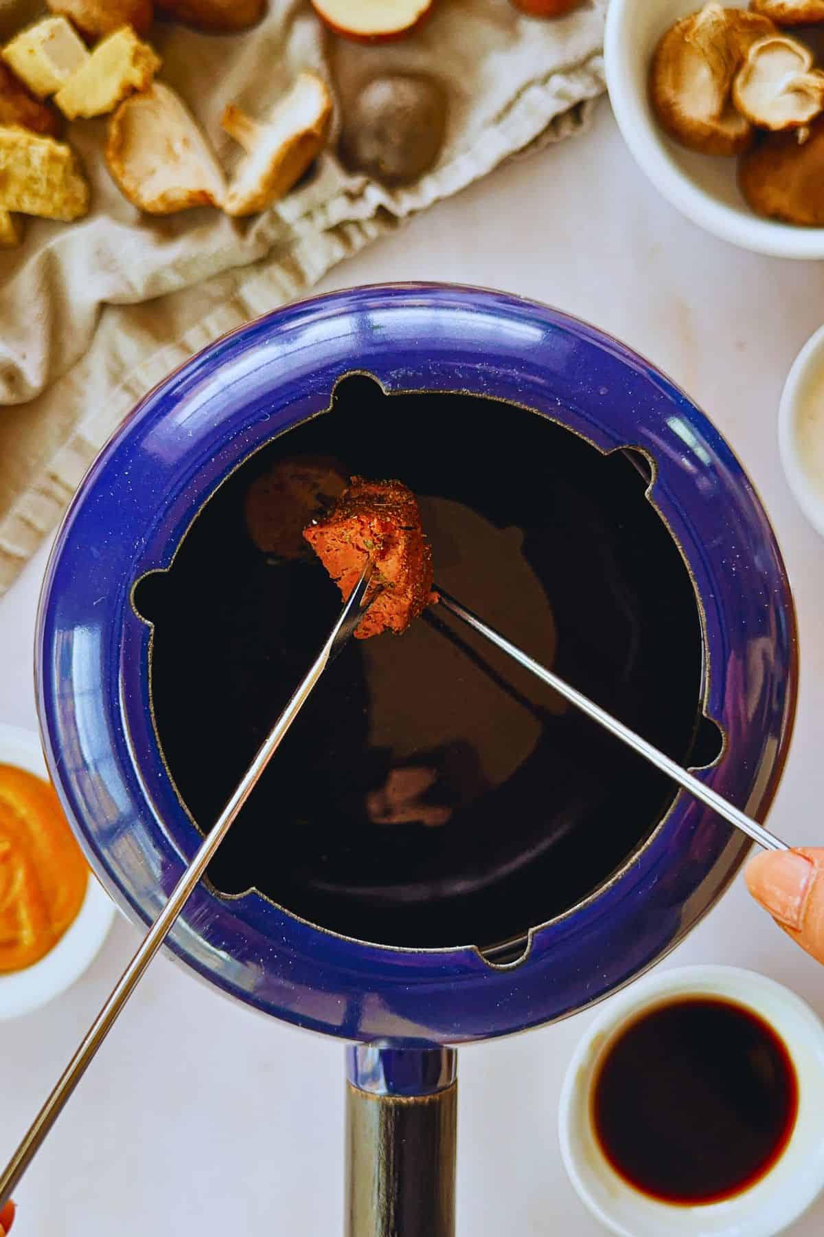 dipping vegan steak into fondue