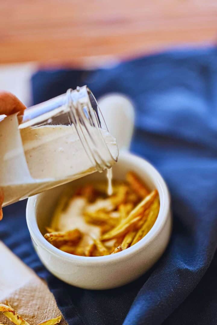 easy vegan aioli pouring from glass container