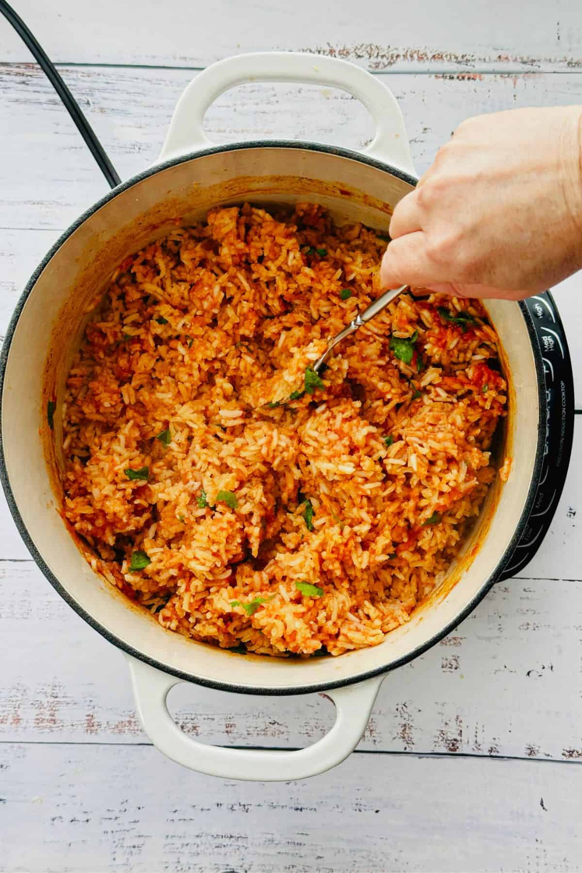 fluffing Spanish rice with a fork