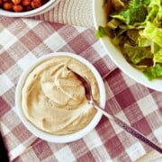 top view of high protein vegan caesar dressing in a bowl with a spoon submerged in it.