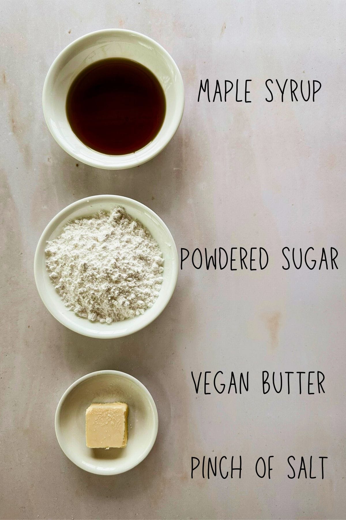 ingredients for maple glaze for gingerbread cookies in bowls; top view