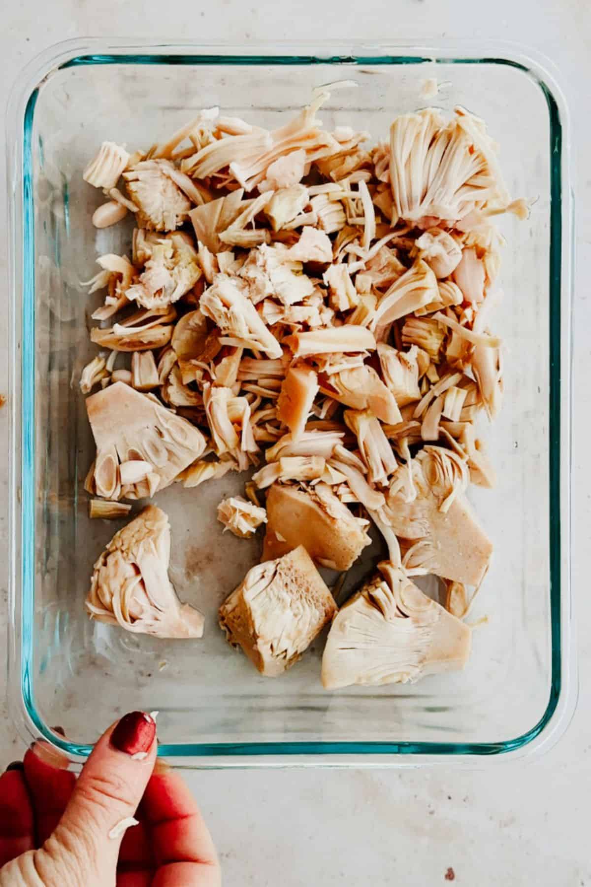 shredding jackfruit in a clear container