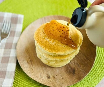 maple syrup pouring on vegan pancakes