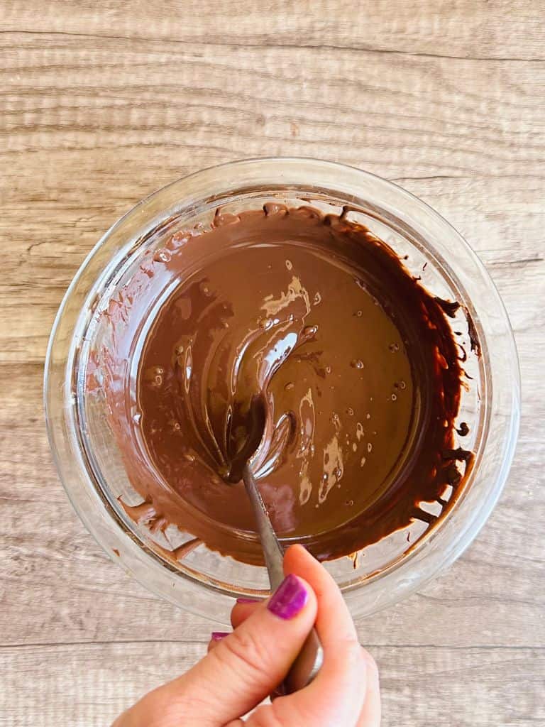 hand mixing melted vegan chocolate in bowl