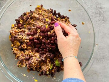 hand mixing in the black beans