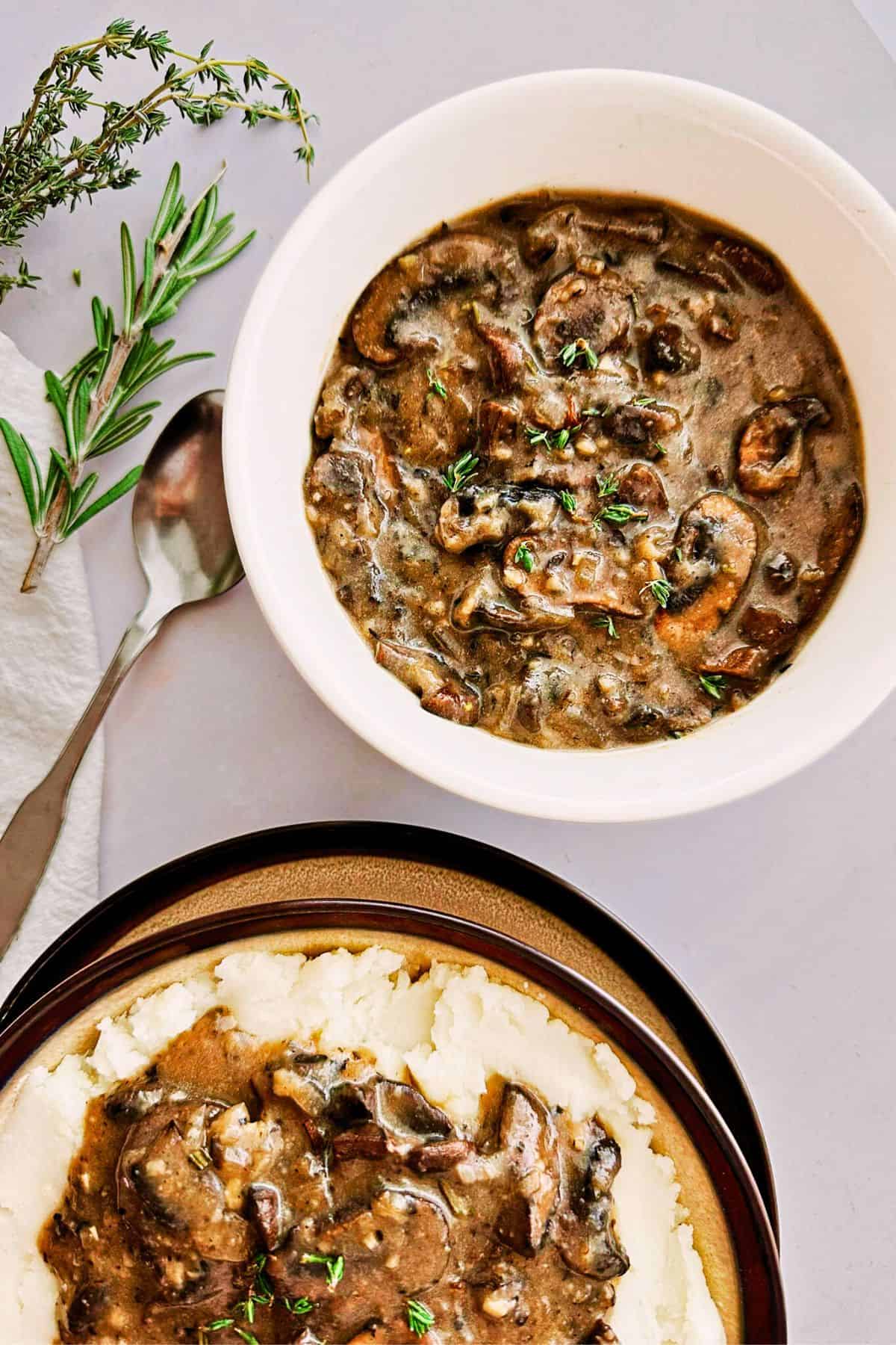 bowl of mushroom vegan gravy next to a plate of mashed potatoes with mushroom vegan gravy