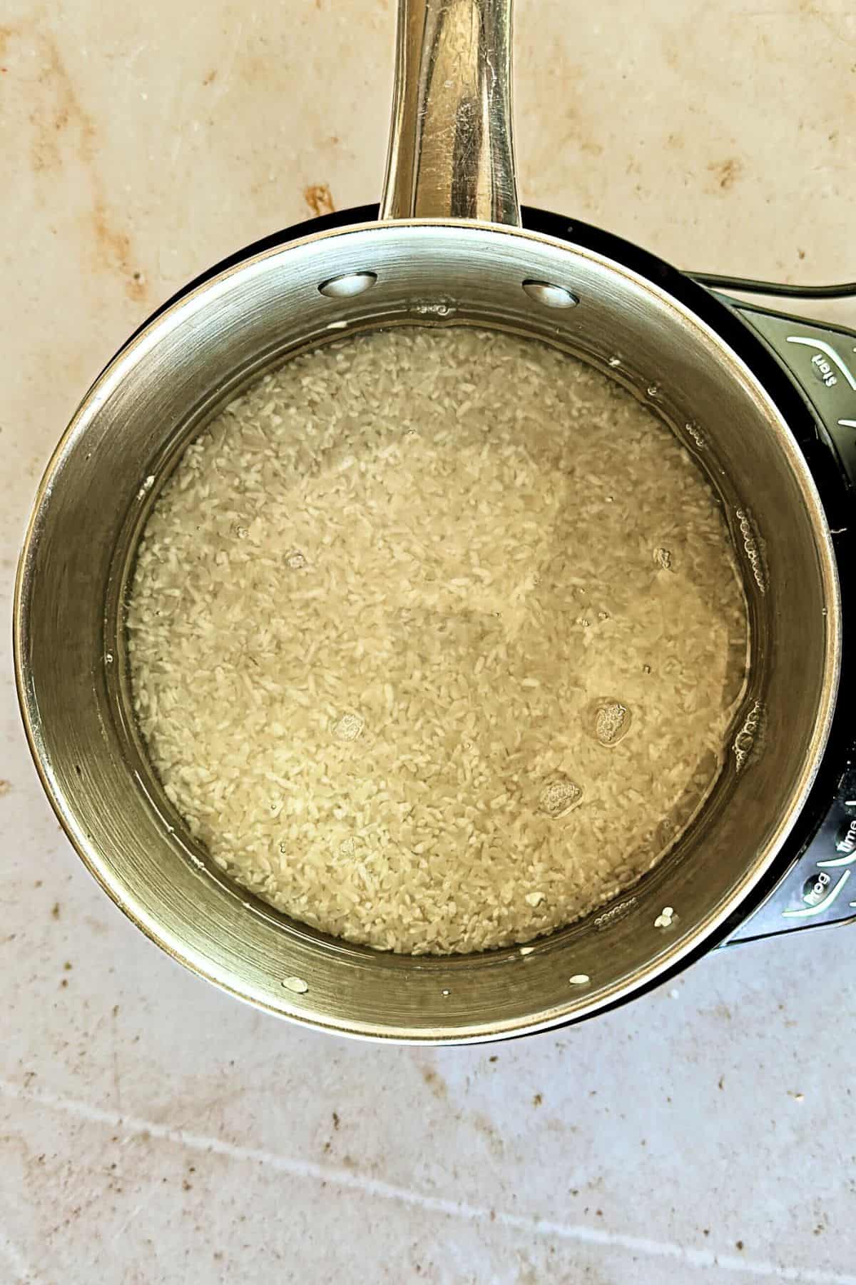 top view of rice in pot for vegan egg roll bowl