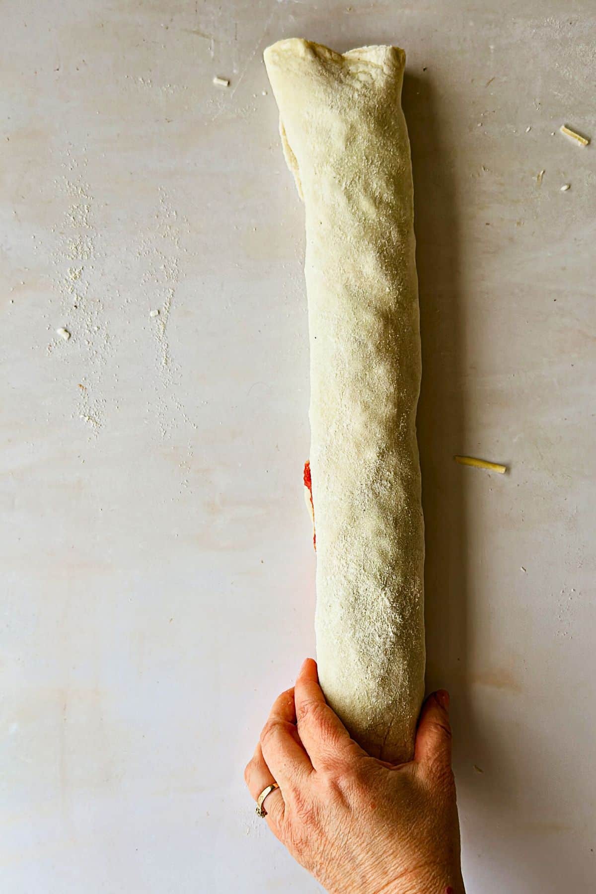 top view of rolling up the dough for vegan pizza rolls