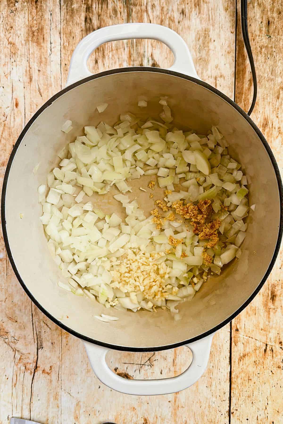 onions, garlic, and ginger in a pot ready to saute