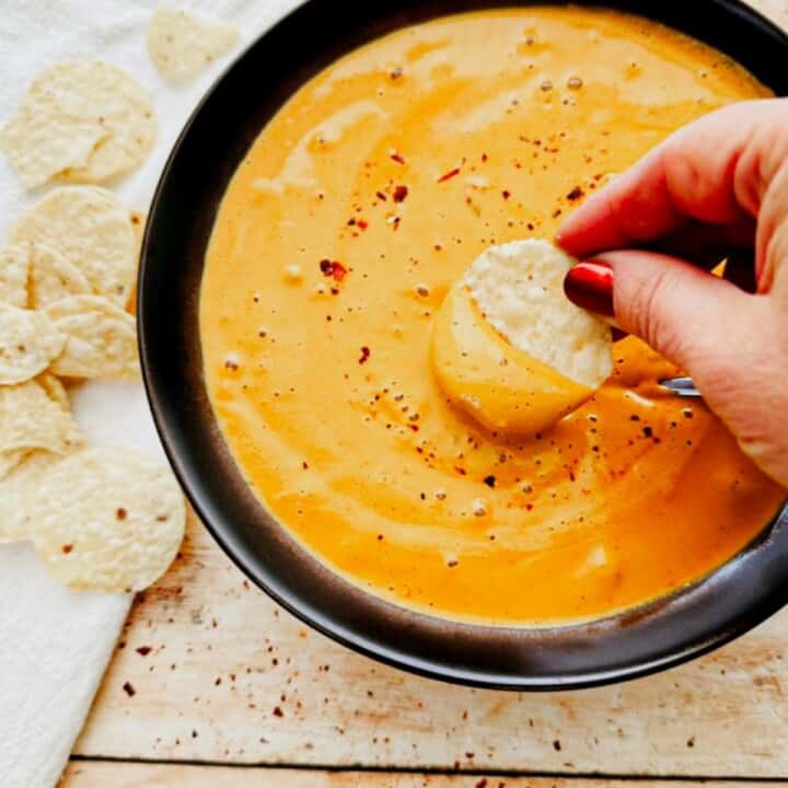 chip being dipped into vegan cashew queso