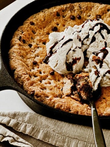 vegan chocolate chip skillet cookie with vegan ice cream and chocolate syrup on top