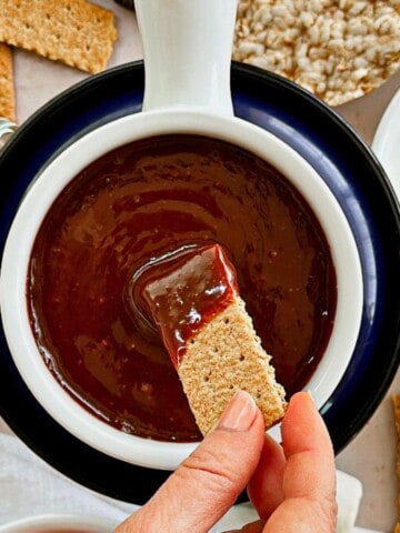 graham cracker dipped into vegan chocolate peanut butter fondue dip; top view