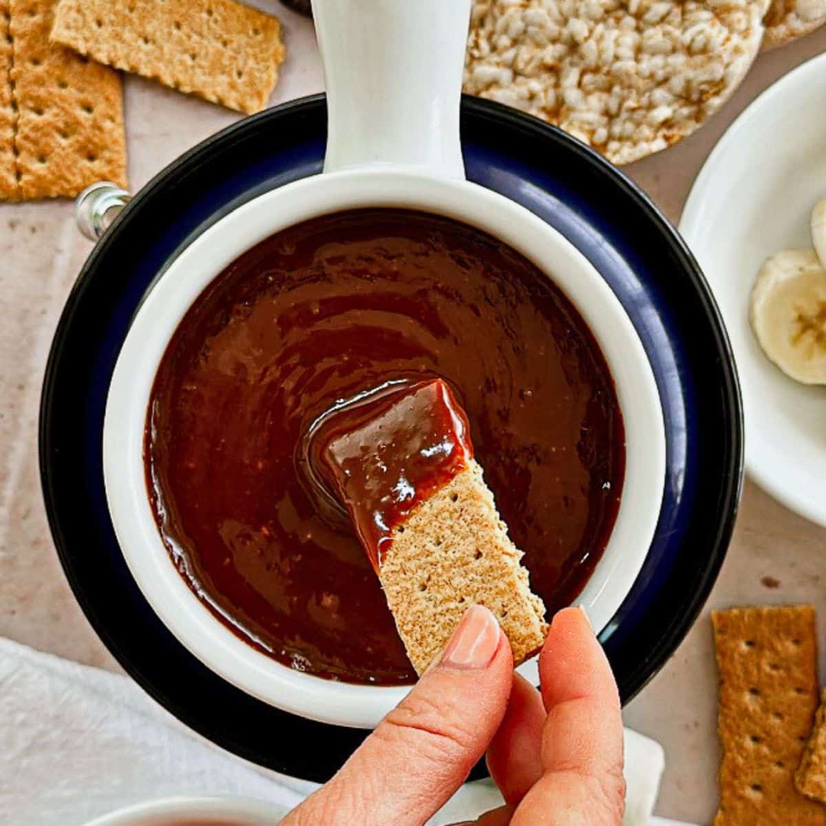 fondue pot with cookie dipped in chocolate