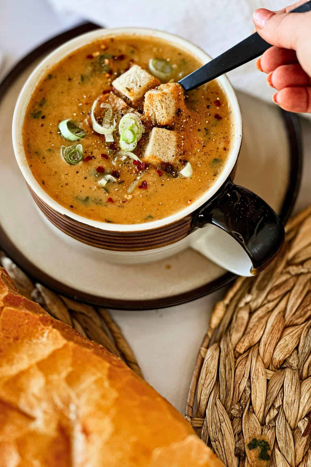 spoon in vegan kale potato leek soup bowl