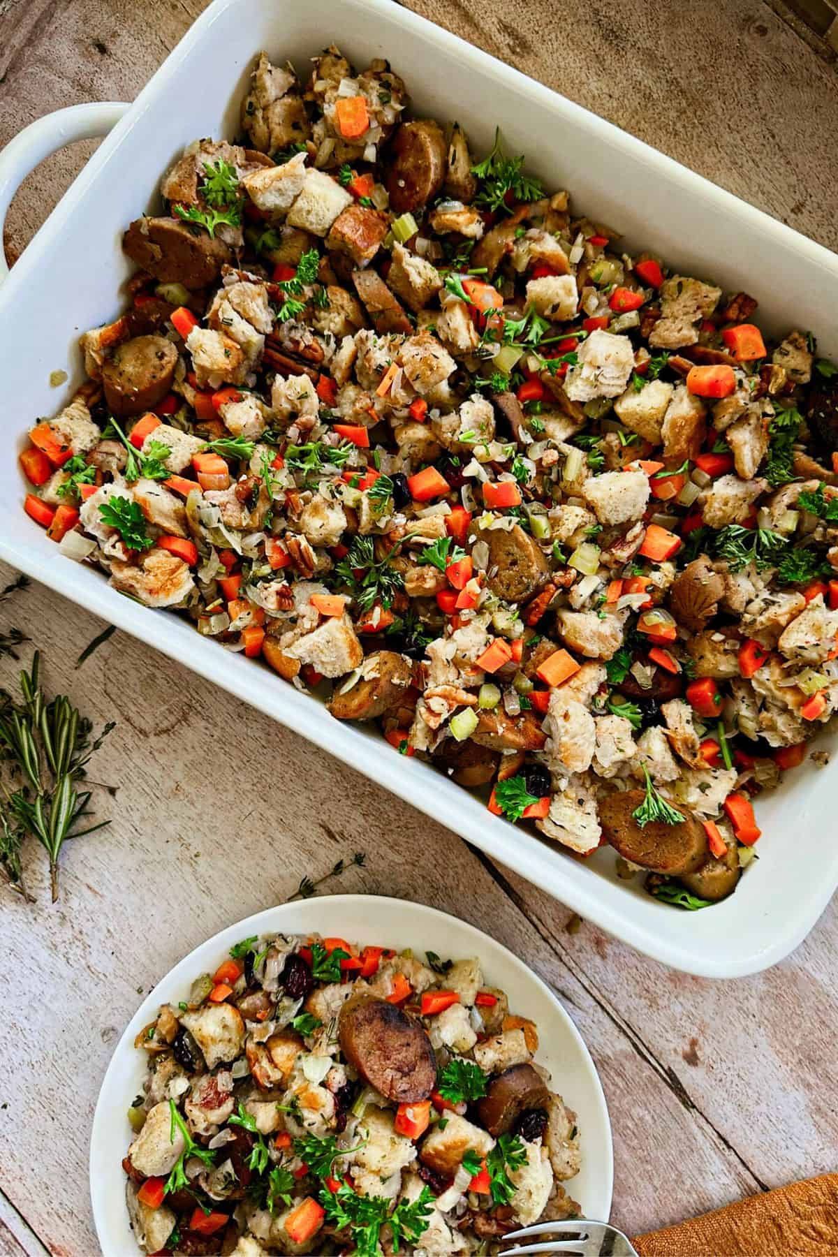 vegan stuffing with cranberries and vegan sausage on a plate and casserole