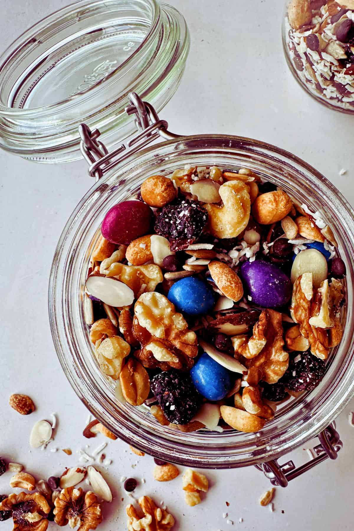 vegan trail mix with unreal chocolate gems in glass container; top view