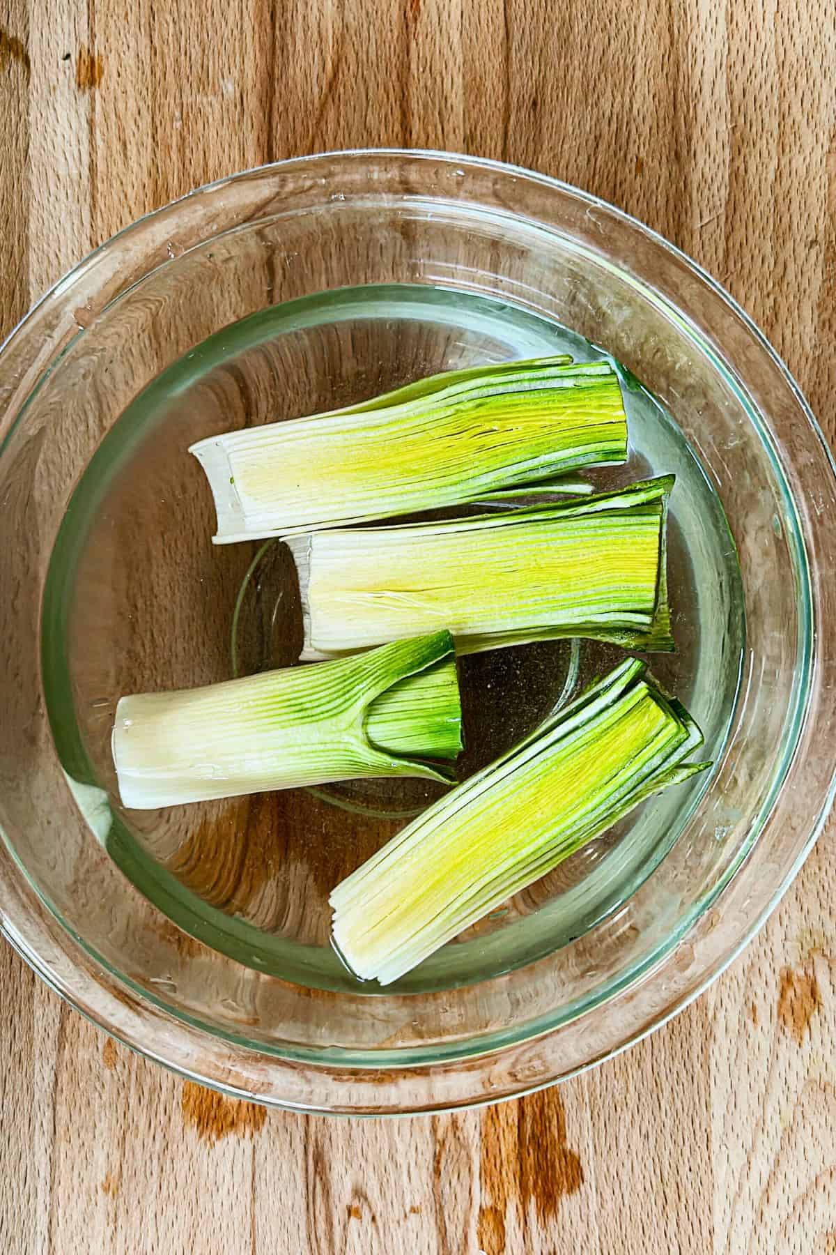 washing leeks in a bowl of water top view