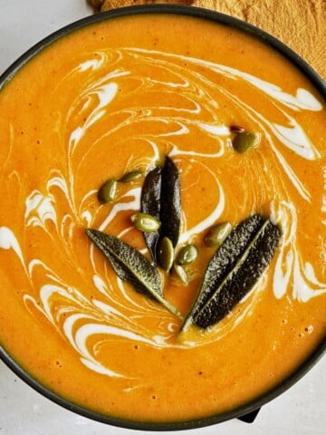 top view of Butternut Squash Carrot Soup in a black bowl.