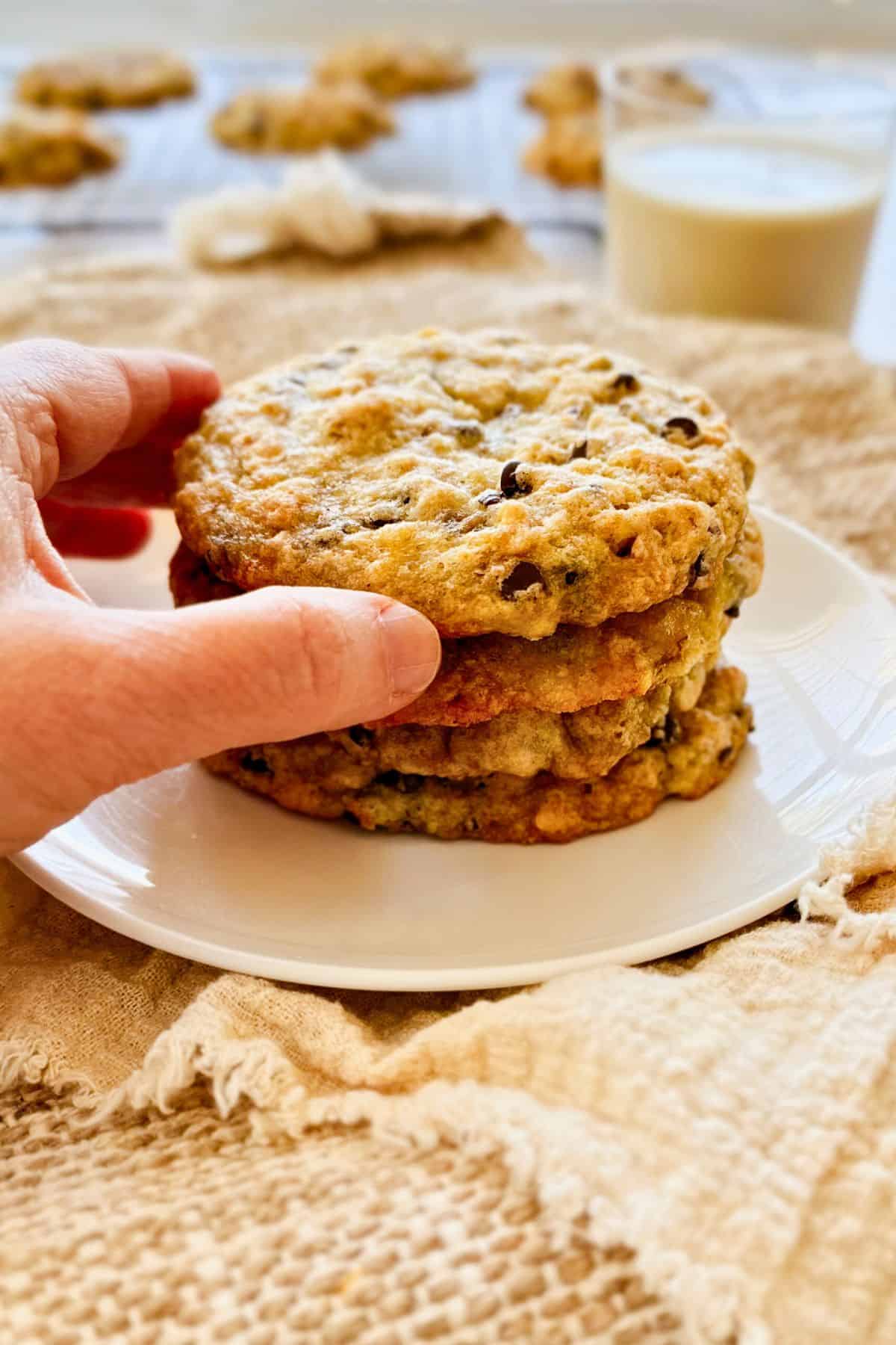 stack of cookies with a hand grabbing the top one.