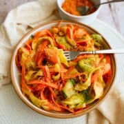 Bowl of cucumber and carrot salad tossed with ginger dressing.