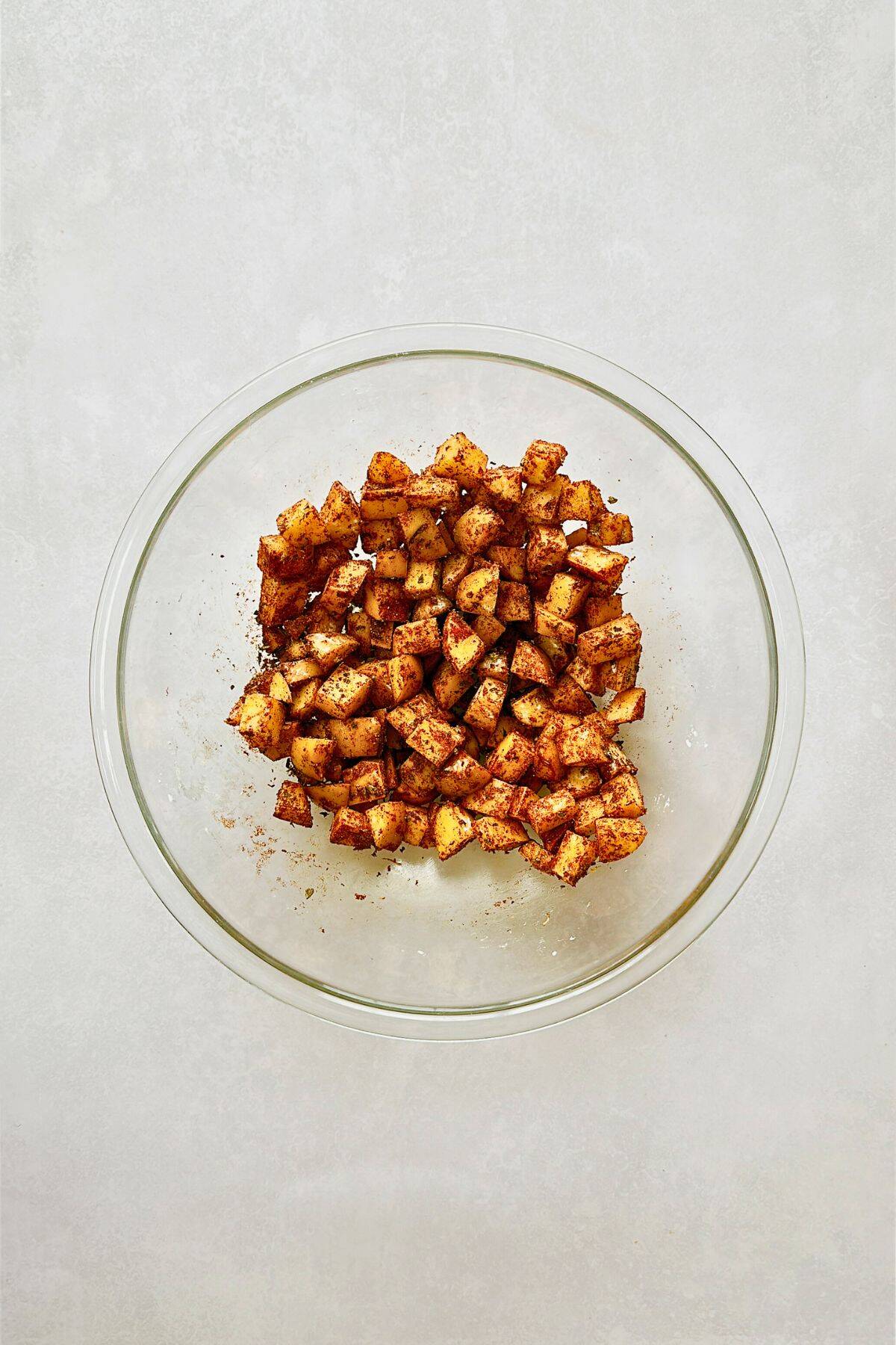 potatoes in a bowl coated with spices.