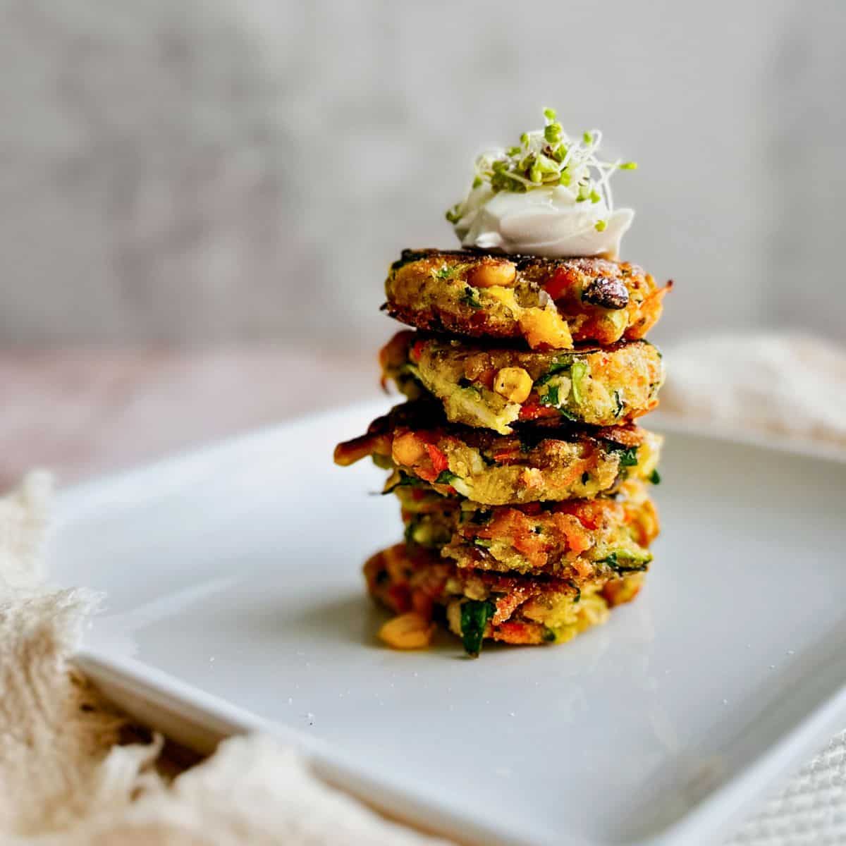 crispy vegetable fritters stacked on a plate.