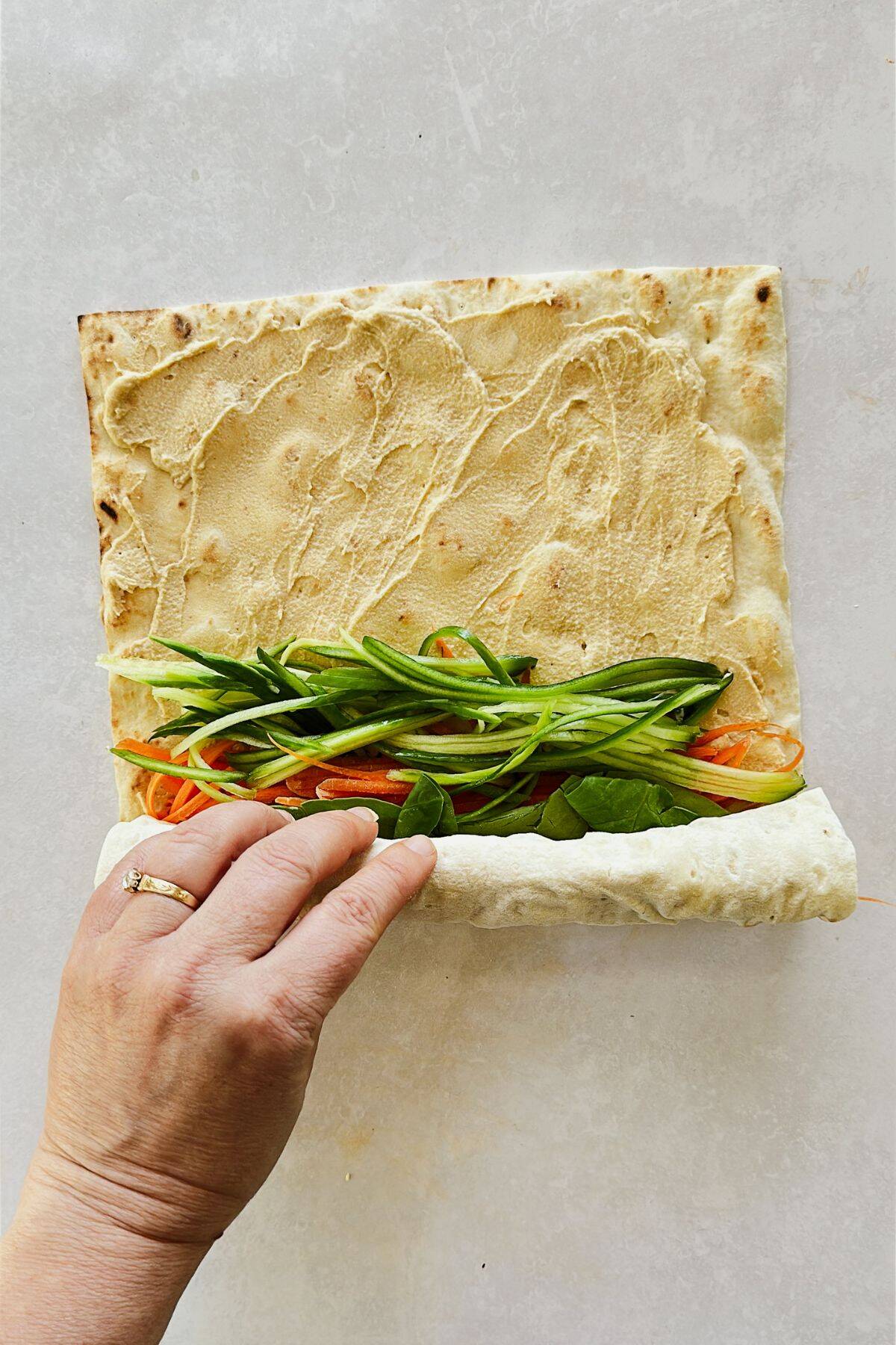 rolling the lavash pinwheels with the veggies and hummus.