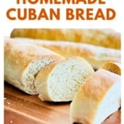 Sliced Cuban bread on a wooden board, showing its soft, fluffy crumb and thin golden crust, with text overlay reading “How to Make Homemade Cuban Bread.