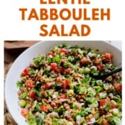 Overhead shot of a bright lentil tabbouleh salad in a white bowl with parsley, tomatoes, cucumber, and onions. Bold text above reads “The Best Lentil Tabbouleh Salad."