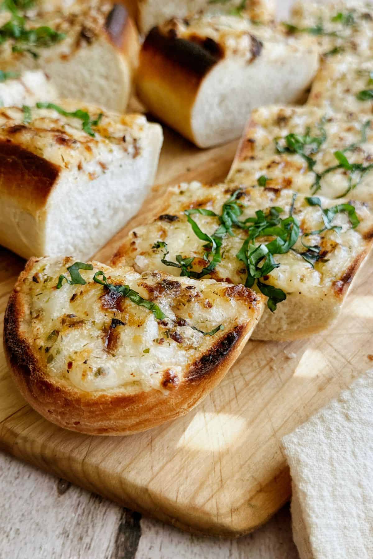 image of the vegan cheesy bread sliced on a cutting board.