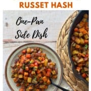 A plate of Sweet Potato and Russet Hash with red peppers and onions beside a cast-iron skillet. Text reads “How to Make Sweet Potato & Russet Hash.”