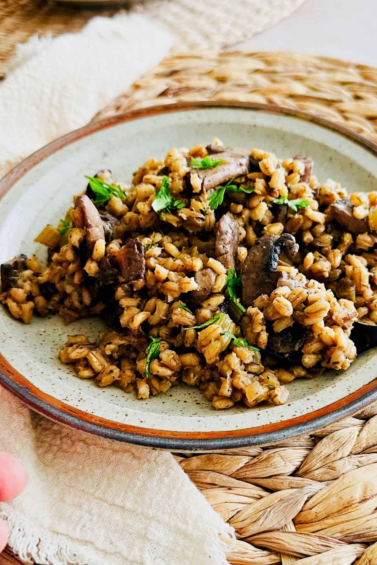 Plate of mushroom barley pilaf garnished with fresh parsley.
