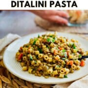 Graphic reading ‘How to Make One-Pot Lentil & Ditalini Pasta’ above a photo of cooked lentils and ditalini pasta served on a white plate on a woven placemat.