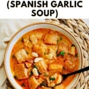 "How to Make Spanish Garlic Soup" text over a bowl of Spanish garlic soup.